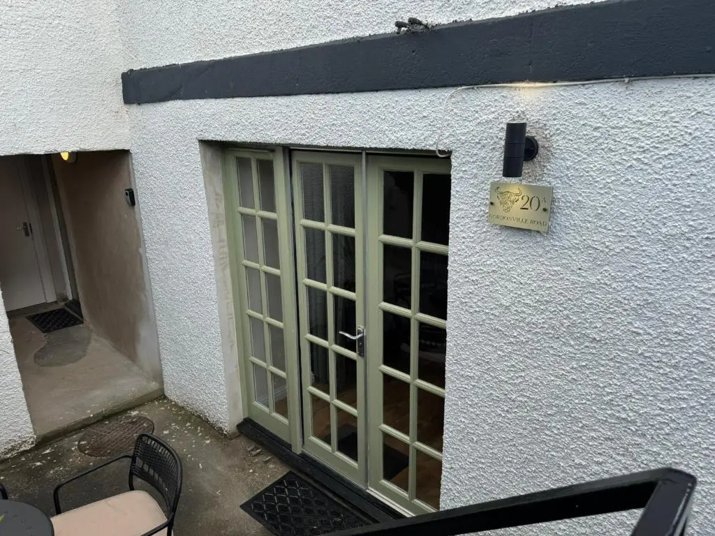 a door with a sign on the side of a building at 20a, By The Ness in Inverness