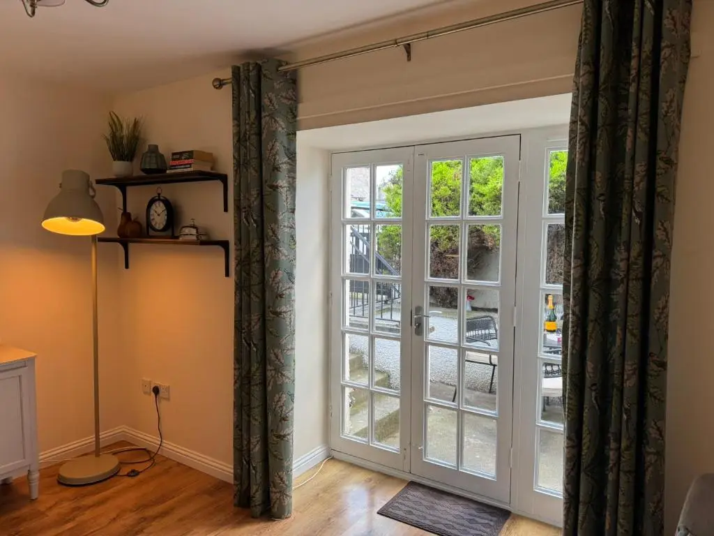 a room with a sliding glass door at 20a, By The Ness in Inverness