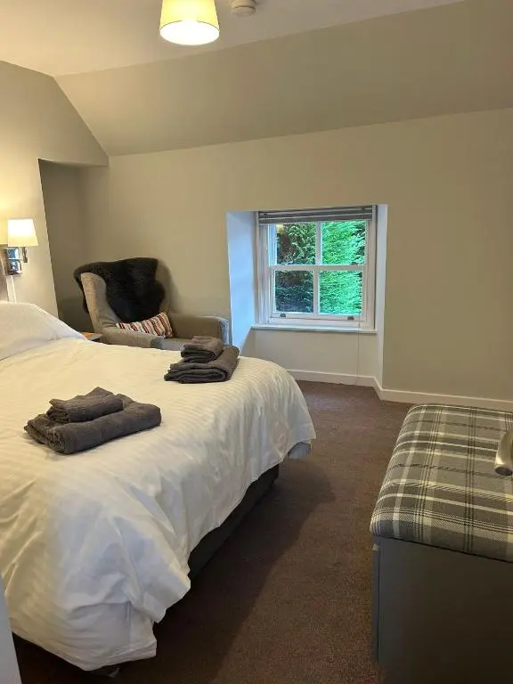 a bedroom with a bed and a chair and a window at 1 Bedroom Alexander Snug-Free Parking in Inverness