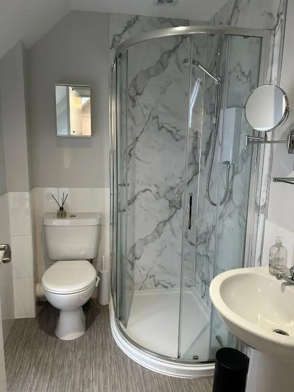 a bathroom with a shower and a toilet and a sink at 1 Bedroom Alexander Snug-Free Parking in Inverness