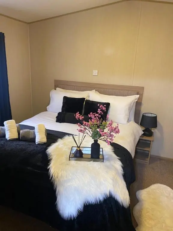 a bedroom with a bed with a table with flowers on it at The mountain retreat in Aviemore