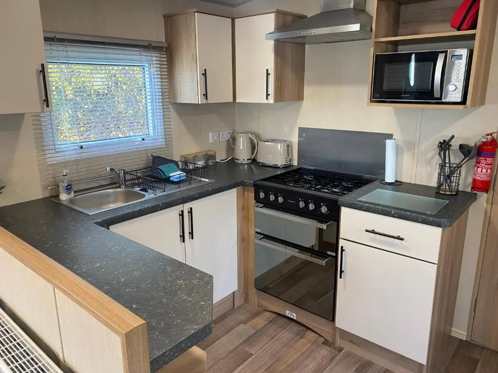 a small kitchen with a stove and a sink at The mountain retreat in Aviemore