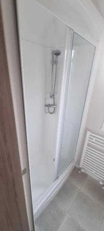 a walk in shower in a room with a glass door at swift LOIRE in Evanton