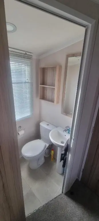a bathroom with a white toilet and a sink at swift LOIRE in Evanton