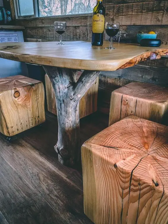 a wooden table with two glasses of wine on top at Ancarraig Lodges in Drumnadrochit