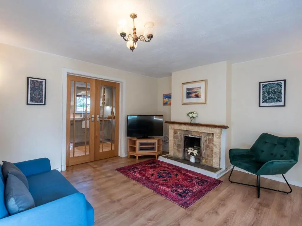 a living room with a blue couch and a fireplace at Holiday Home Jenkins Cottage by Interhome in Fort Augustus