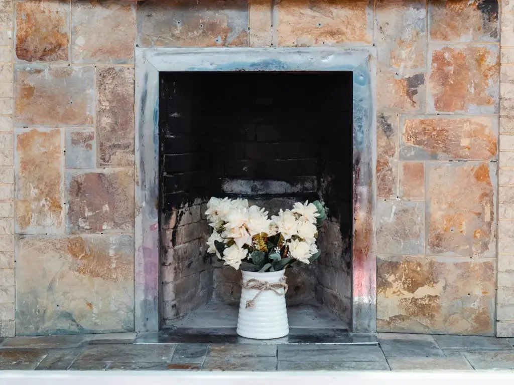 a vase filled with white flowers in a brick wall at Holiday Home Jenkins Cottage by Interhome in Fort Augustus