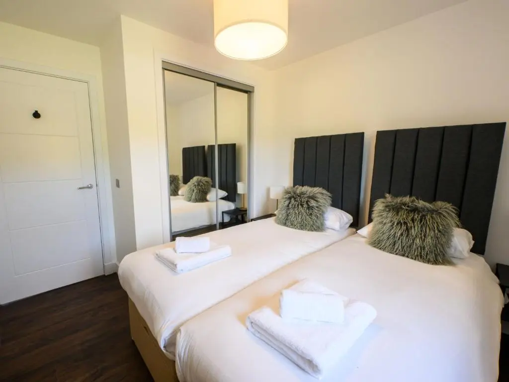 two beds in a room with a mirror at Apartment Craigmonie Apartment by Interhome in Drumnadrochit