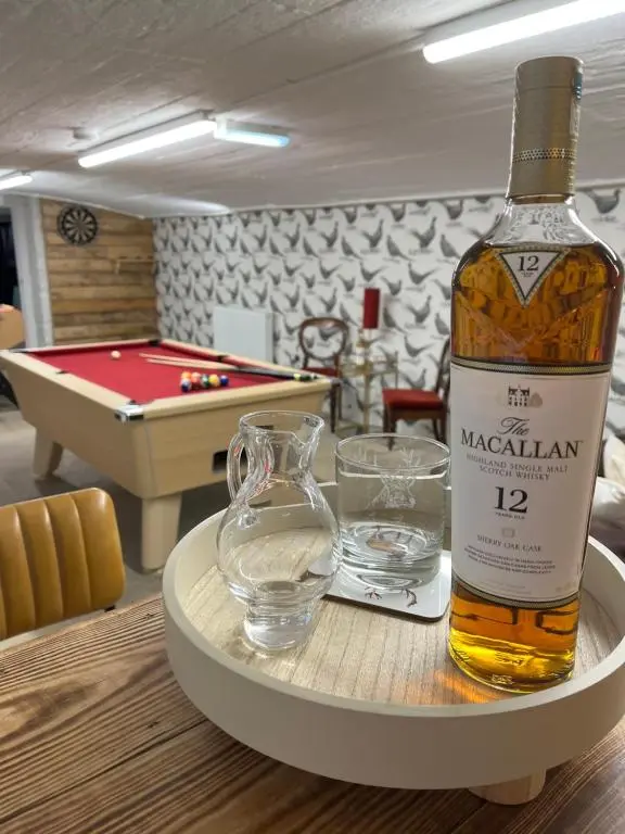 a bottle of whiskey on a table with a glass of water and a table at The Urquhart in Oldmeldrum