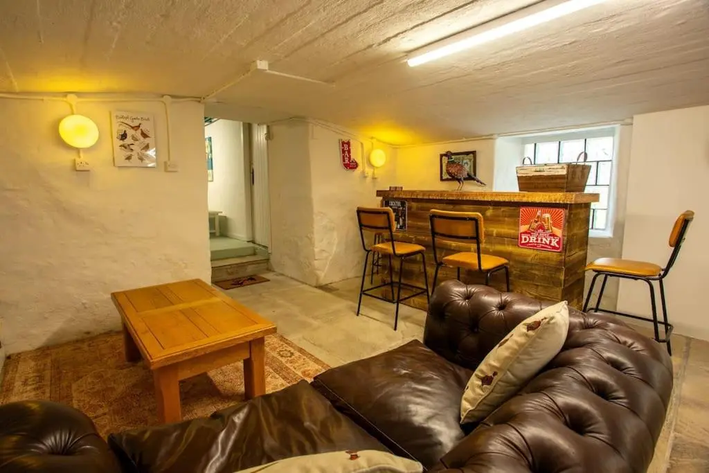 a living room with a leather couch and a table at The Urquhart in Oldmeldrum