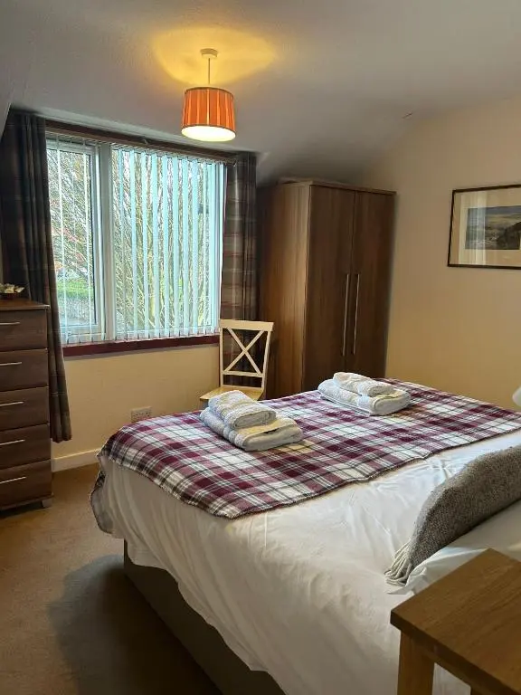 a bedroom with a bed with towels on it at 2 Bedroom Sheneval House Free Parking in Inverness