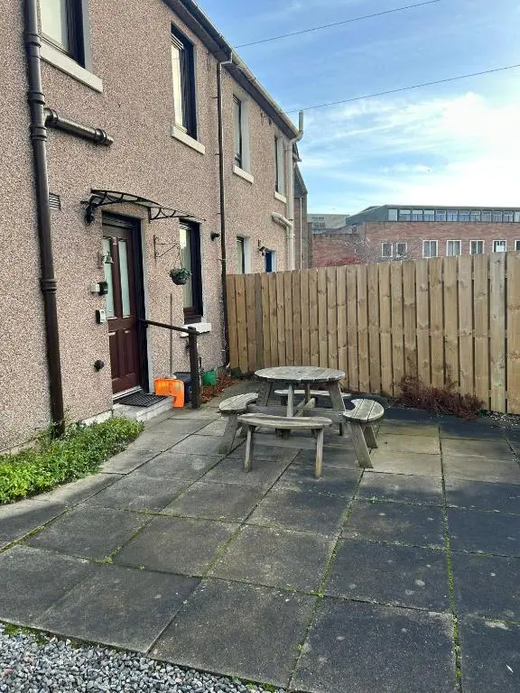 a picnic table in front of a wooden fence at 2 Bedroom Sheneval House Free Parking in Inverness