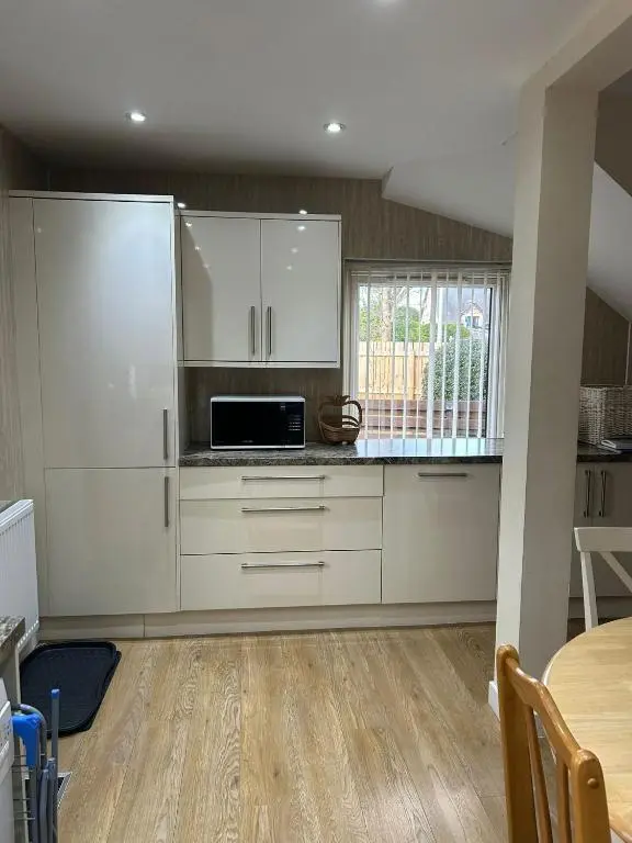 a kitchen with white cabinets and a microwave at 2 Bedroom Sheneval House Free Parking in Inverness