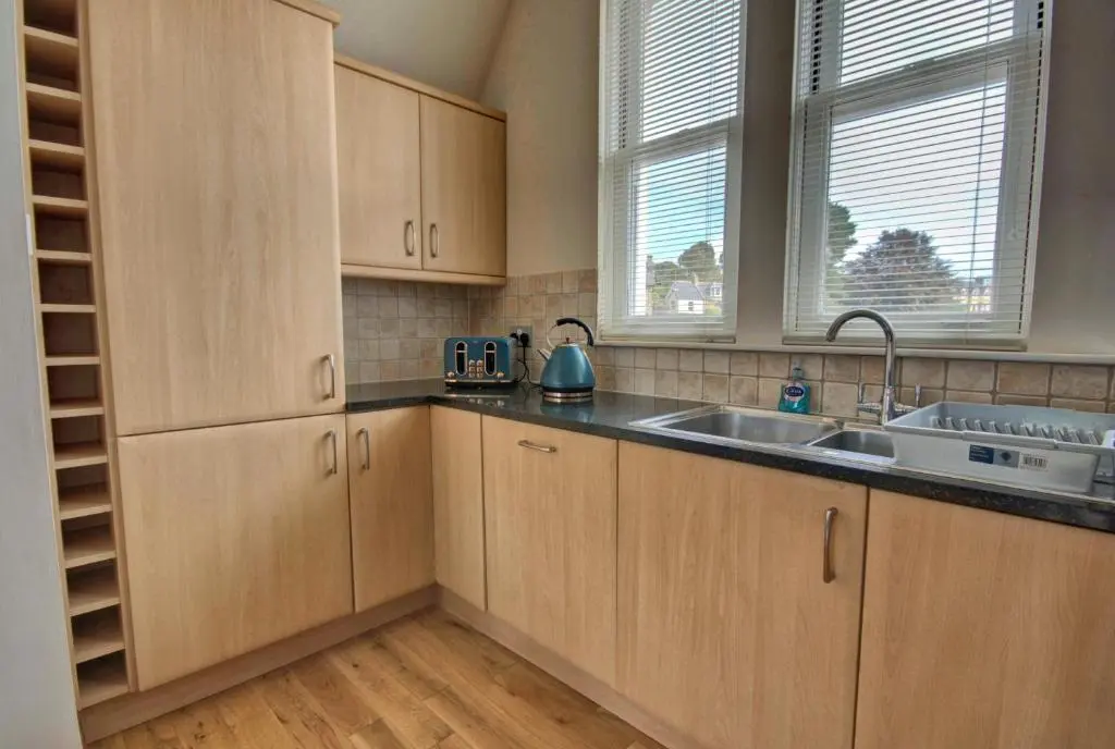 a kitchen with wooden cabinets and a sink at 1 Argyle Place, Dornoch in Dornoch