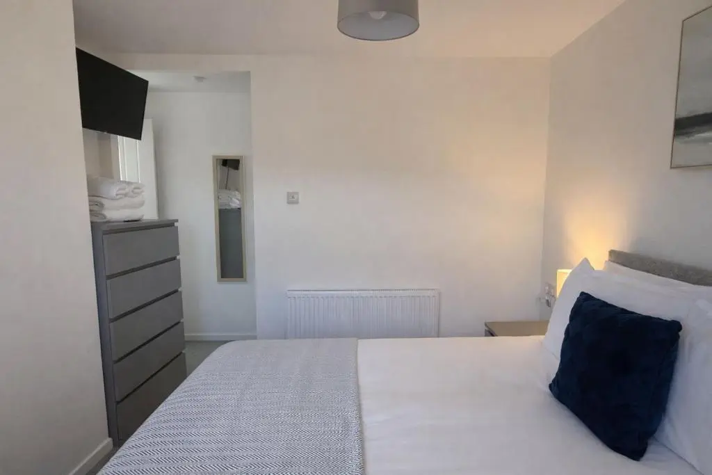 a bedroom with a white bed with a blue pillow at Charlie's View in Inverness