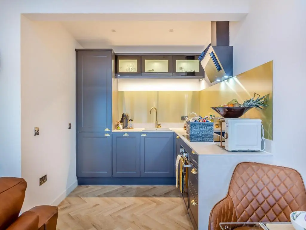 a kitchen with blue cabinets and a sink at Kimcraigan Lodge in Lochend