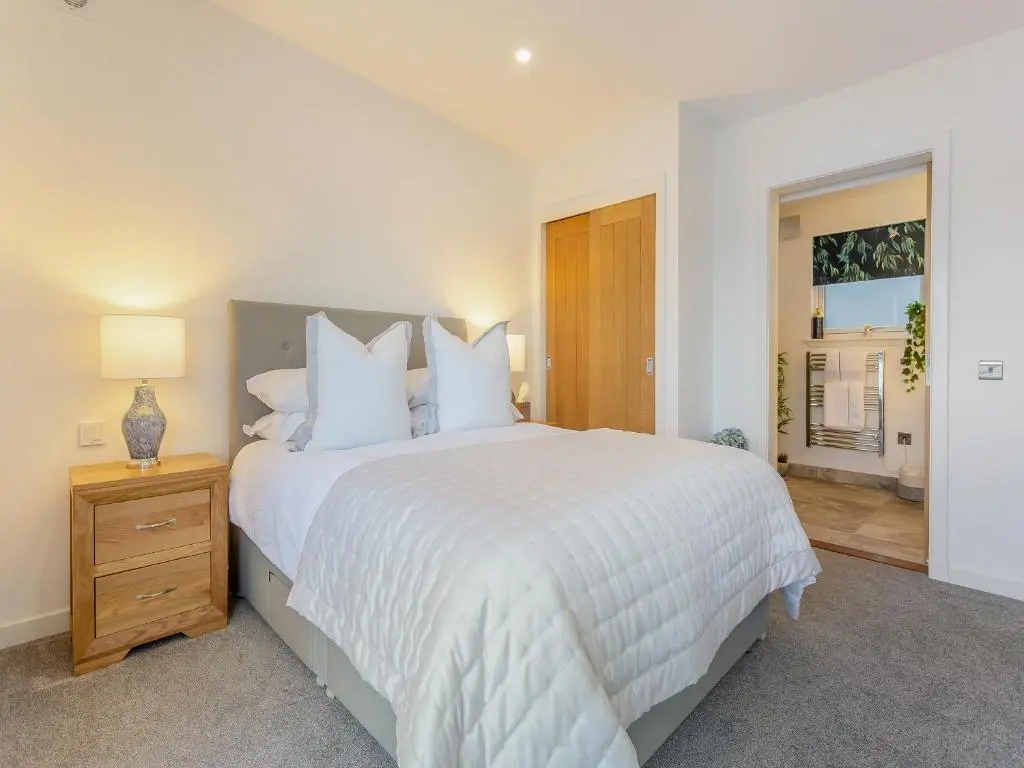 a white bedroom with a large bed and a window at Kimcraigan Lodge in Lochend