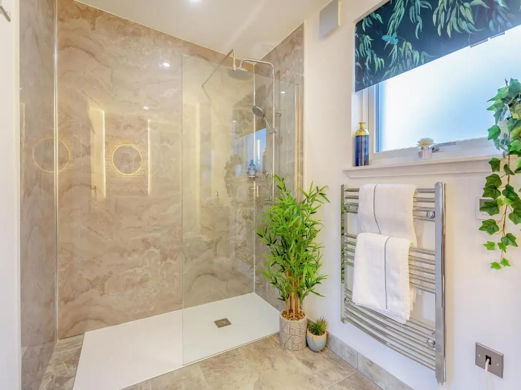 a bathroom with a shower and a plant at Kimcraigan Lodge in Lochend