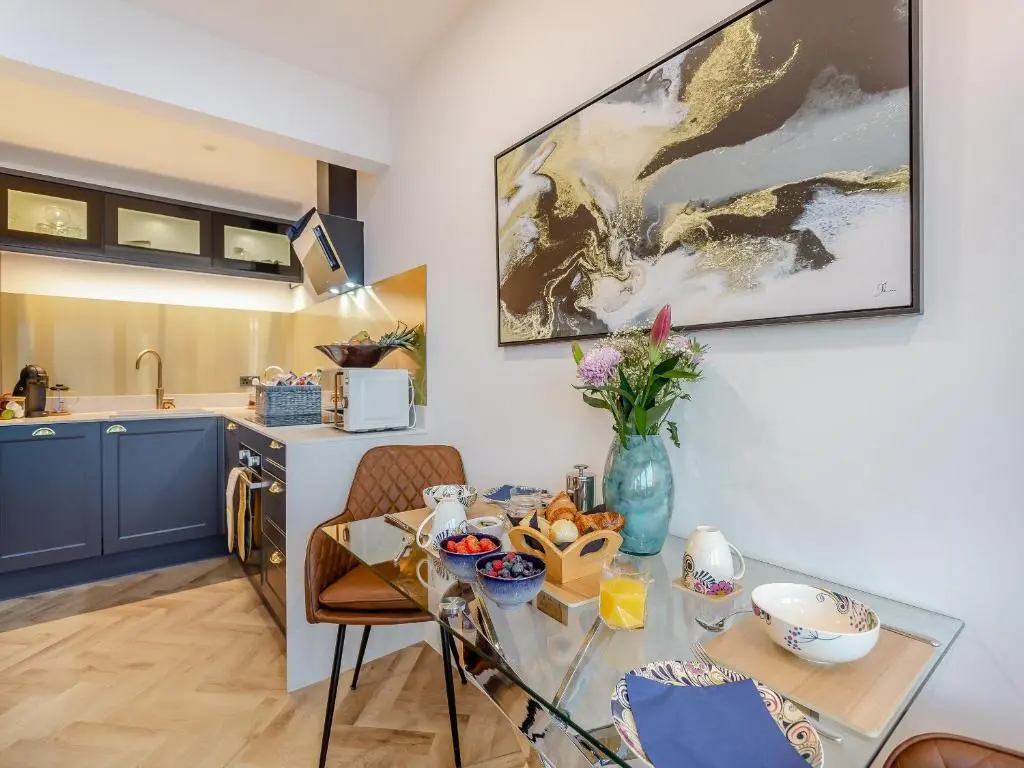 a kitchen and a dining room with a table and a kitchen at Kimcraigan Lodge in Lochend