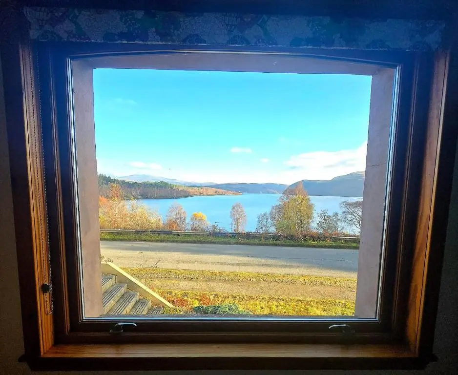 a window with a view of a lake at Luichart Lodge in Lochluichart Station