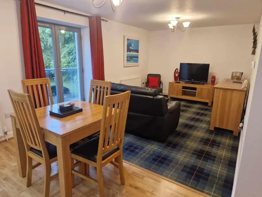 a living room with a table and a couch at Glen Mor in Fort Augustus