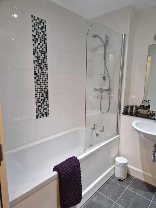 a bathroom with a shower and a tub and a sink at Glen Mor in Fort Augustus