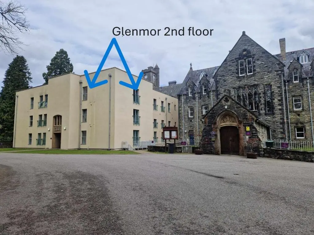 a large building with a blue arrow in front of it at Glen Mor in Fort Augustus