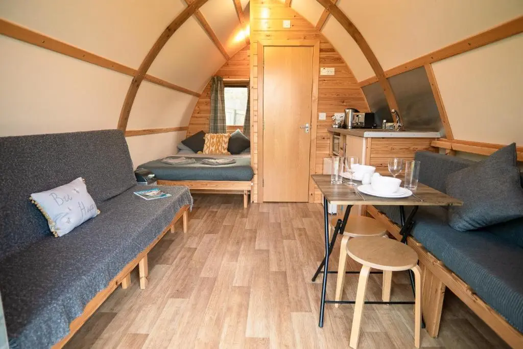 a room with couches and a table in a tiny house at The Loft by Wigwam Holidays in Kinloss