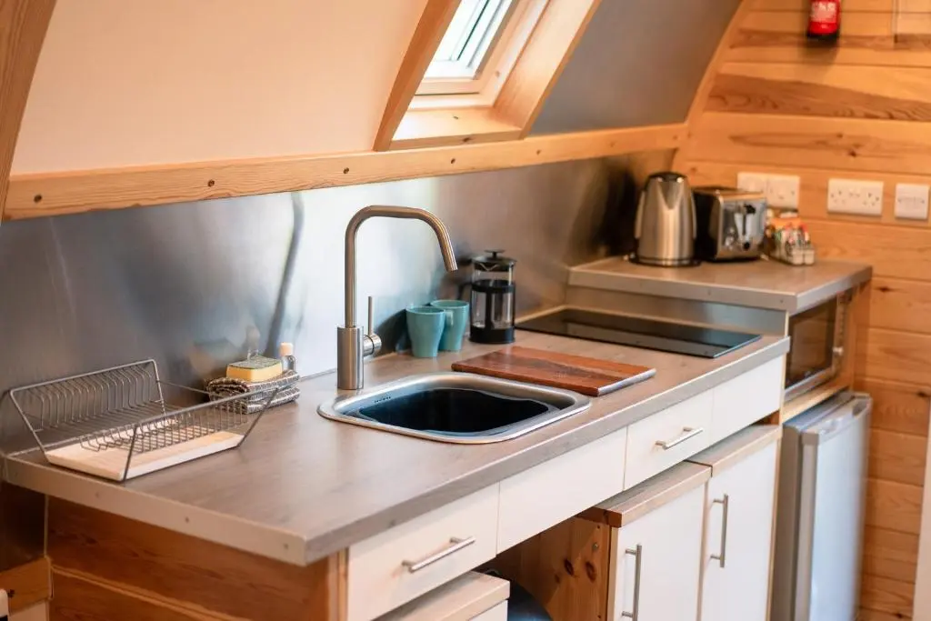 a kitchen with a sink in a tiny house at The Loft by Wigwam Holidays in Kinloss