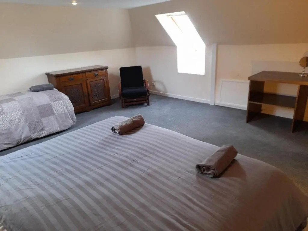 a bedroom with a bed and a desk and a chair at The Granary in Buckie