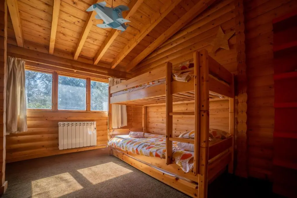 a log cabin bedroom with two bunk beds at Our Log House in the woods in Balnald