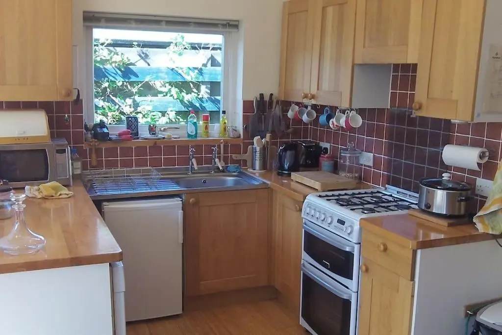 a kitchen with a sink and a stove top oven at Taigh Sona easy access apartment with double bed in Ullapool