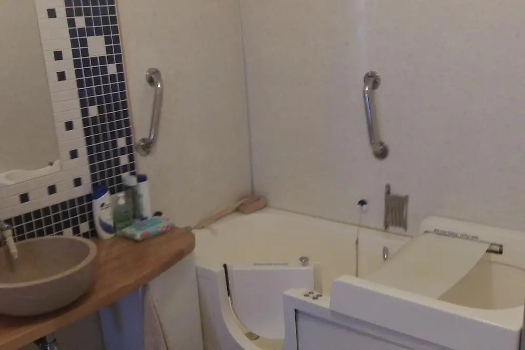 a bathroom with a sink and a toilet and a tub at Taigh Sona easy access apartment with double bed in Ullapool