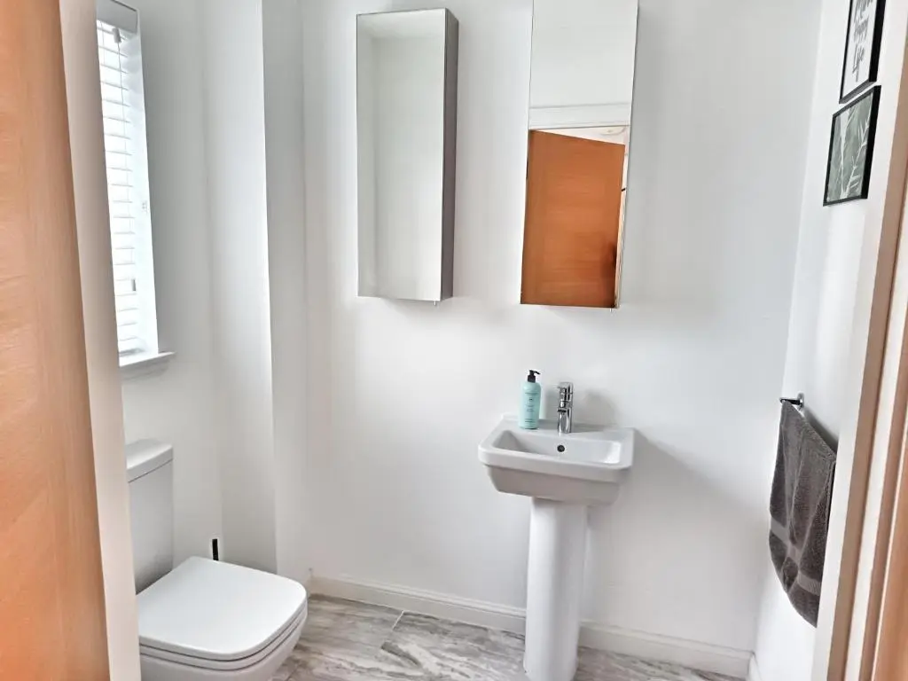 a white bathroom with a toilet and a sink at 4 miles to Westhill by Lains Lettings in Aberdeen