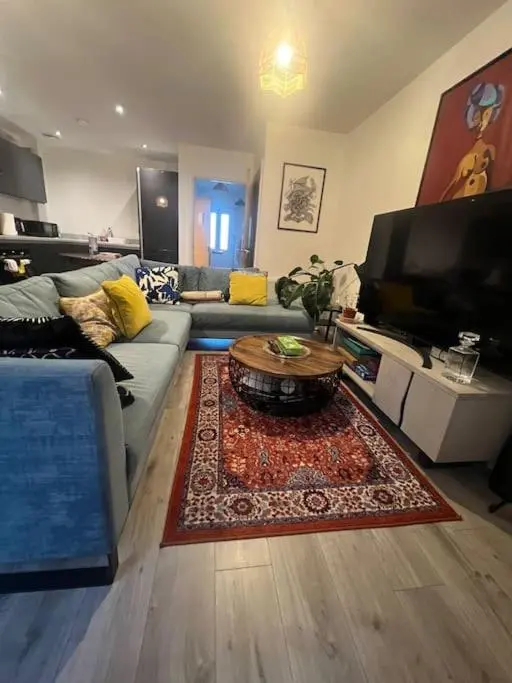 a living room with a couch and a table at Lovely 2 bedroom home, free parking, 6 mins from airport in Bankhead