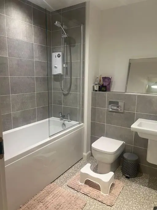 a bathroom with a shower and a toilet and a sink at Lovely 2 bedroom home, free parking, 6 mins from airport in Bankhead