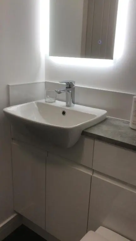 a white sink in a bathroom with a mirror at Elgin Studios in Elgin