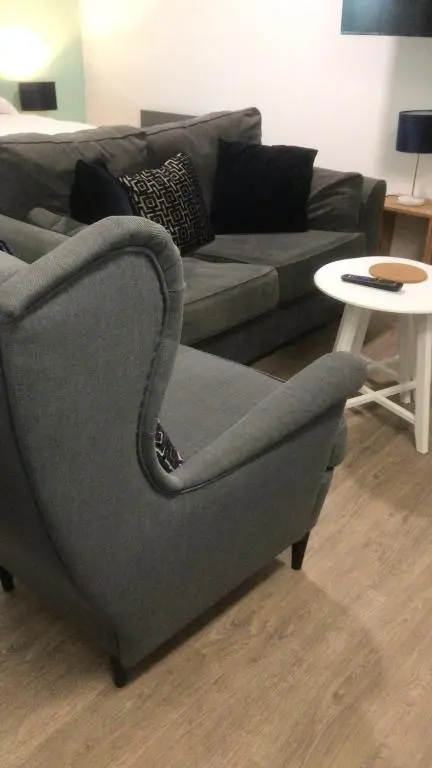 a couch and a chair in a living room at Elgin Studios in Elgin