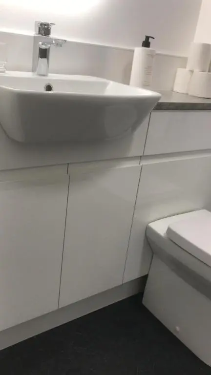 a white bathroom with a sink and a toilet at Elgin Studios in Elgin