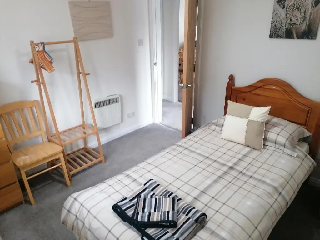 a bedroom with a bed and a chair and a ladder at House in Alness in Alness
