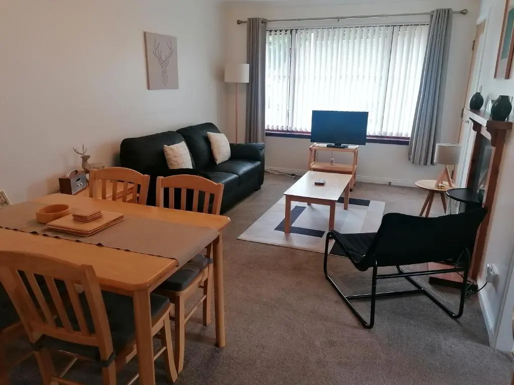 a living room with a table and a couch at House in Alness in Alness
