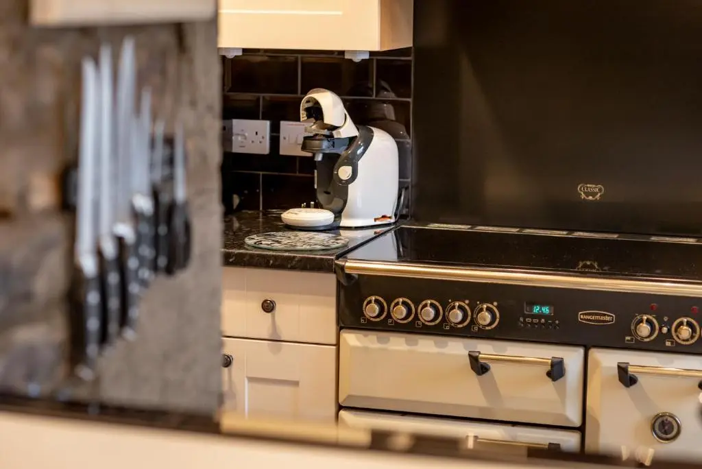 a kitchen counter with a stove and a mixer at Falls Cottage in Glenlivet