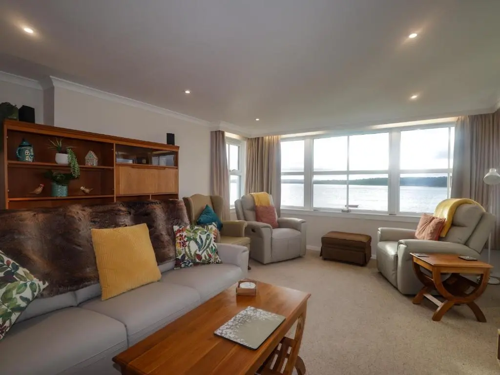 a living room with a couch and a table at Bayside Cottage in Forres