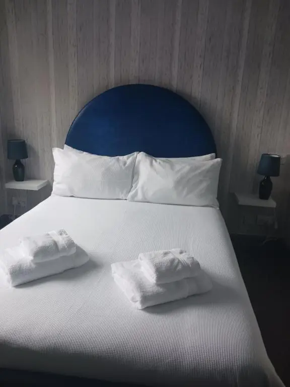 a large white bed with two towels on it at Friars Bridge Guesthouse in Inverness