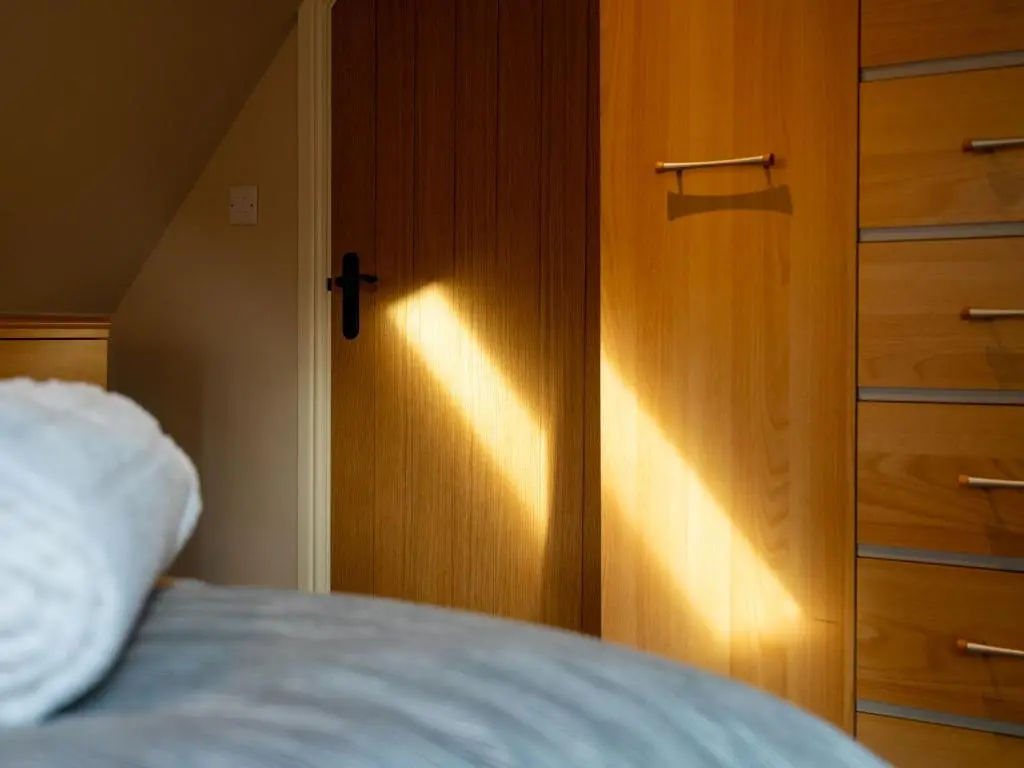 a bedroom with a bed and a cross on a closet at Holiday Home Rose Cottage by Interhome in Farr