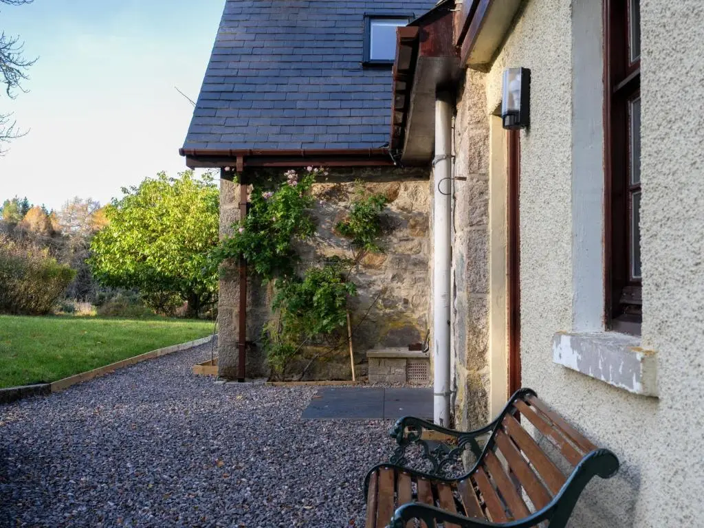 a wooden bench sitting outside of a building at Holiday Home Rose Cottage by Interhome in Farr
