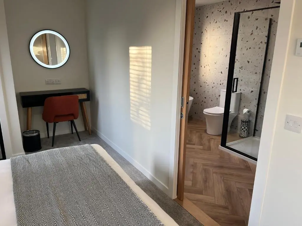 a bathroom with a mirror and a table and a chair at Thrumster Lodges - 3 Luxurious Self Catering Lodges on the NC500, 2 with Hot Tubs in Wick