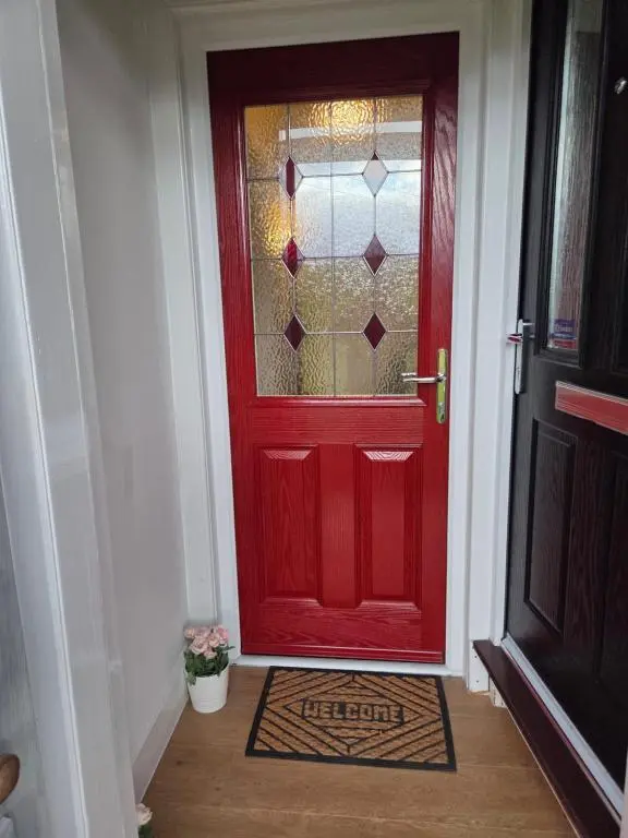 a red door with a glass window on it at Ardgay in Fort Augustus