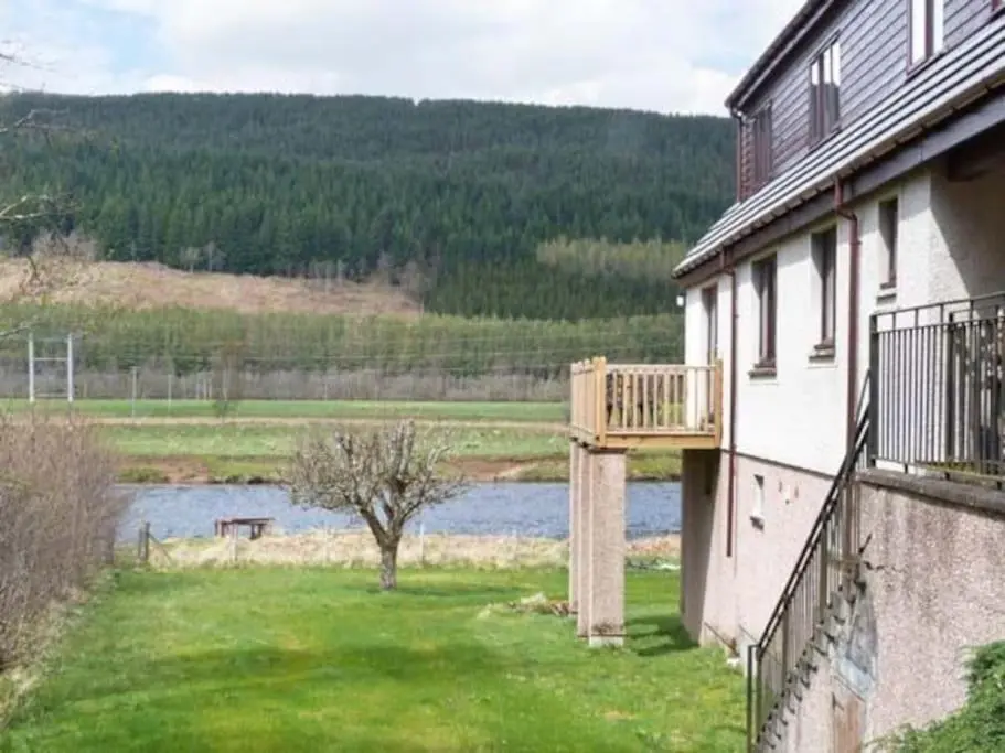 a balcony of a house with a view of a river at Kerrow Burn Lodge Cannich Inverness-shire in Invercannich