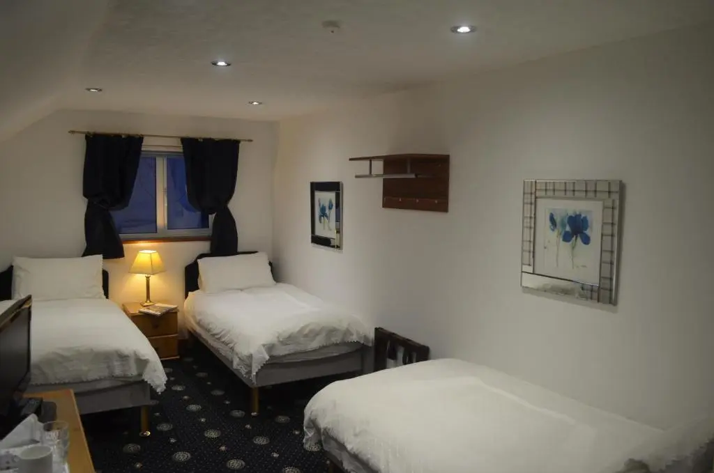 a hotel room with two beds and a window at Roseneath Guest House in Inverness